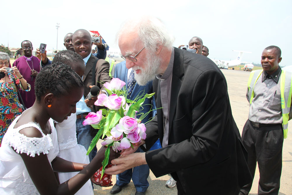 A welcomer greets the Archbishop with flowers